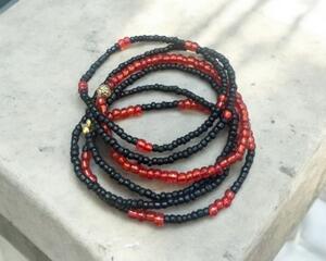 This is a handmade red and black 5 stack stretchy seed bead bracelet.